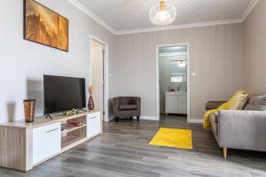 a living room with a couch and a television at Oásis Fonte Grande in Ponta Delgada