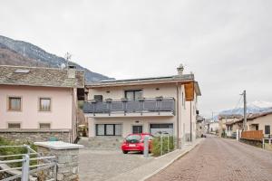a red car parked in front of a building at Appartamento Alice in Caiolo