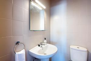 a bathroom with a sink and a toilet and a mirror at Best place Playamar in Torremolinos +18 photos