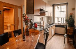 a kitchen with a wooden table with wine glasses on it at Fewos Deutschherrenstraße in Trier +21 photos