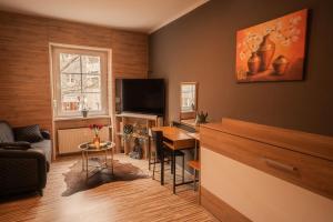 a living room with a table and a television at Fewos Deutschherrenstraße in Trier