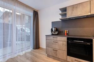 a kitchen with a stove and a large window at Grauzone Grossarl App Nr 1 Cozy in Grossarl