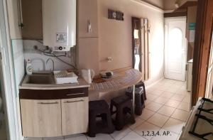 a small kitchen with a sink and a table at CSABA-EMILKA-SPA Apartmanok in Hajdúszoboszló