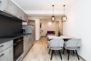 a kitchen with a table and chairs in a room at Grauzone Grossarl App Nr 1 Cozy in Grossarl