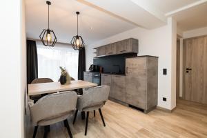 a kitchen and dining room with a wooden table and chairs at Grauzone Grossarl App Nr 1 Cozy in Grossarl