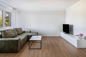 a living room with a couch and a tv at Zimis Hofnest in Freiamt