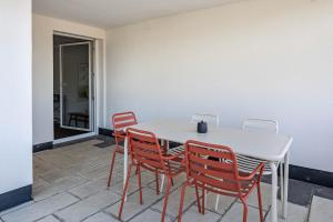 a white table and four red chairs in a room at Zimis Hofnest in Freiamt