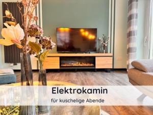 a living room with a tv and a fireplace at Ferienwohnung Auszeit Harz in Bad Sachsa