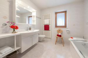 a white bathroom with a sink and a toilet at Wohnung Schlern Heigler Hof in Collepietra +21 photos