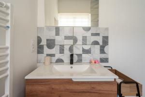 a bathroom with a white sink and a mirror at Au petit chez nous in Cozes