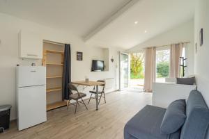 a kitchen and living room with a couch and a table at Au petit chez nous in Cozes