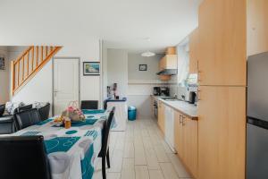 a kitchen with a table with chairs and a kitchen with at Gite Les Dauphins à Matignon in Matignon