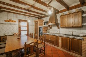 a large kitchen with a wooden table and a sink at Casa Rural Los Beatos in Urueña
