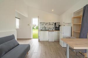 a kitchen and living room with a couch and a table at Au petit chez nous in Cozes +12 photos