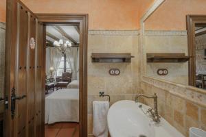 a bathroom with a sink and a mirror and a bedroom at Casa Rural Los Beatos in Urueña +30 photos