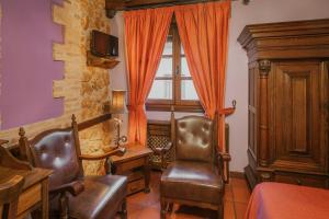 a living room with two chairs and a window at Casa Rural Los Beatos in Urueña