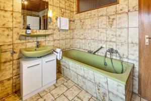 a bathroom with a tub and a sink at Ferienwohnungen Martin Lafar in Öhningen +143 photos