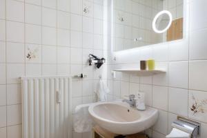a white bathroom with a sink and a mirror at Fewo Kessler Schwarzwaldstüble in Häusern +15 photos