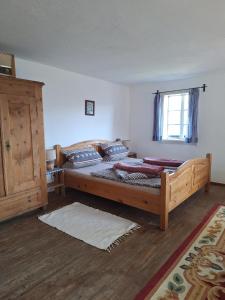 a bedroom with a large wooden bed with a window at Adlerhütte in Stall