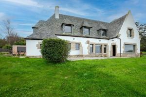 a white house with a gray roof on a green field at Villa Ker Louise in Locquirec