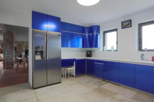 a kitchen with blue cabinets and a refrigerator at Villa Ker Louise in Locquirec