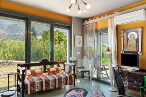 a living room with a couch and a tv at Livadi House Amorgos in Aegiali