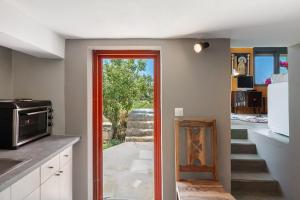 a kitchen with a door leading into a kitchen with a staircase at Livadi House Amorgos in Aegiali
