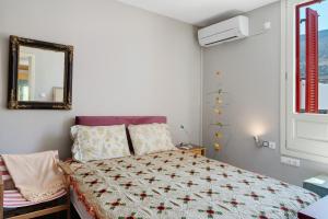 a bedroom with a bed with a quilt on it at Livadi House Amorgos in Aegiali
