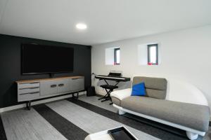 a living room with a television and a couch and a desk at Villa Ker Louise in Locquirec