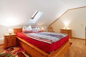 a bedroom with a wooden bed with red sheets at Haus Albatros Wohnung 4 in Koserow