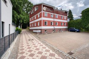 a large red building with a car parked next to it at Haus Albatros Wohnung 4 in Koserow