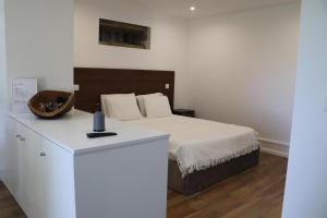 a bedroom with a bed and a white table at Casa do Mestre Inteira in Vila de Punhe +72 photos