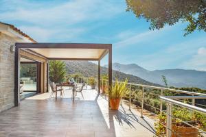 a patio with a table and a view of the mountains at Villa Kalliste in Olmeto