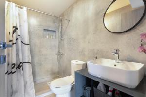 a bathroom with a sink and a toilet and a mirror at Villa Andreas in Athani
