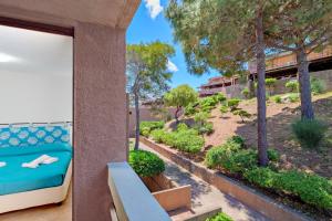 a balcony with a bed and trees in a building at Casa Ioana in Cugnana Verde