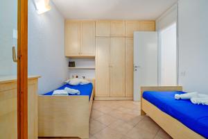 a small room with two beds and wooden cabinets at Casa Ioana in Cugnana Verde
