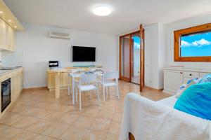 a kitchen and living room with a table and chairs at Casa Ioana in Cugnana Verde