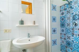 a white bathroom with a sink and a shower at Casa Idda in Linguaglossa