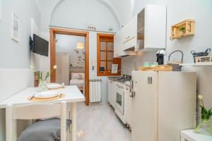 a small kitchen with white appliances and a table at Casa Idda in Linguaglossa