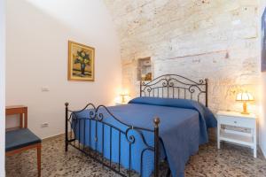 a bedroom with a blue bed and a stone wall at Corallo House in Polignano a Mare +62 photos