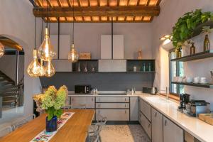 a kitchen with a wooden table and some lights at Le Sughere in Riparbella