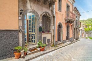 an alley with a door and potted plants on a street at Casa Idda in Linguaglossa