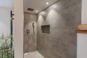a shower in a bathroom with a stone wall at Haus Elisabeth in Lauf +22 photos
