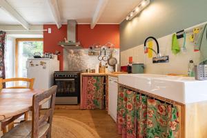a kitchen with a sink and a refrigerator and a table at La Casita in Beauvène +12 photos