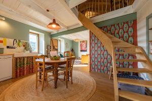 a kitchen and dining room with a table and a staircase at La Casita in Beauvène