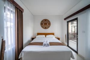 a bedroom with a bed and a window at Sachi Guest House in Jimbaran