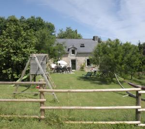 a yard with a wooden fence and a house at Gîte Le Penn-ty in Rosporden