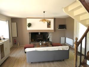 a living room with a couch and a fireplace at Gîte Le Penn-ty in Rosporden