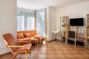 a living room with a couch and a tv at Ferienwohnung am Neumagen in Staufen im Breisgau