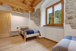 a bedroom with two beds and a window at Casa al Mulino 1 in Tenno